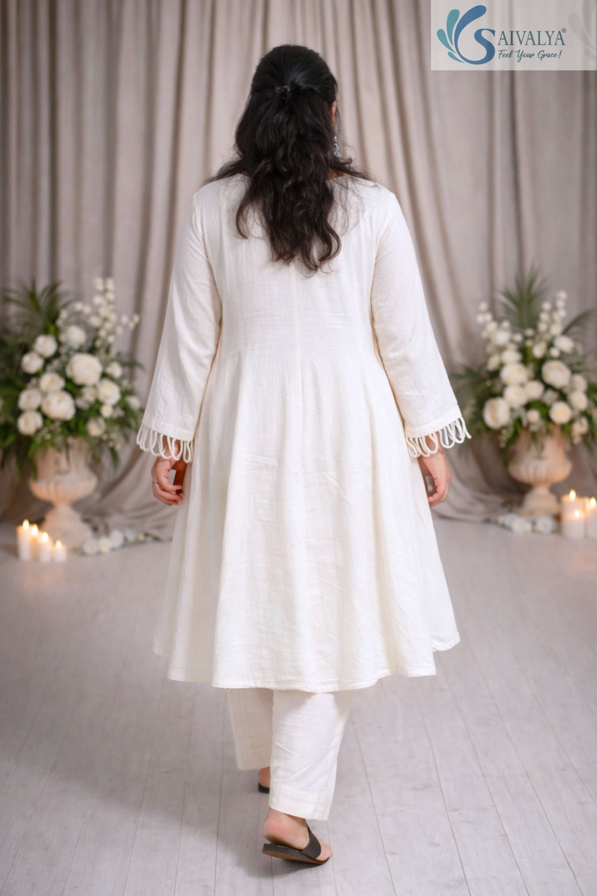 Back view of a woman wearing the Saivalya Ivory Loop Grace Suit showcasing the sophisticated fit and the flow of the ethnic ivory suit set