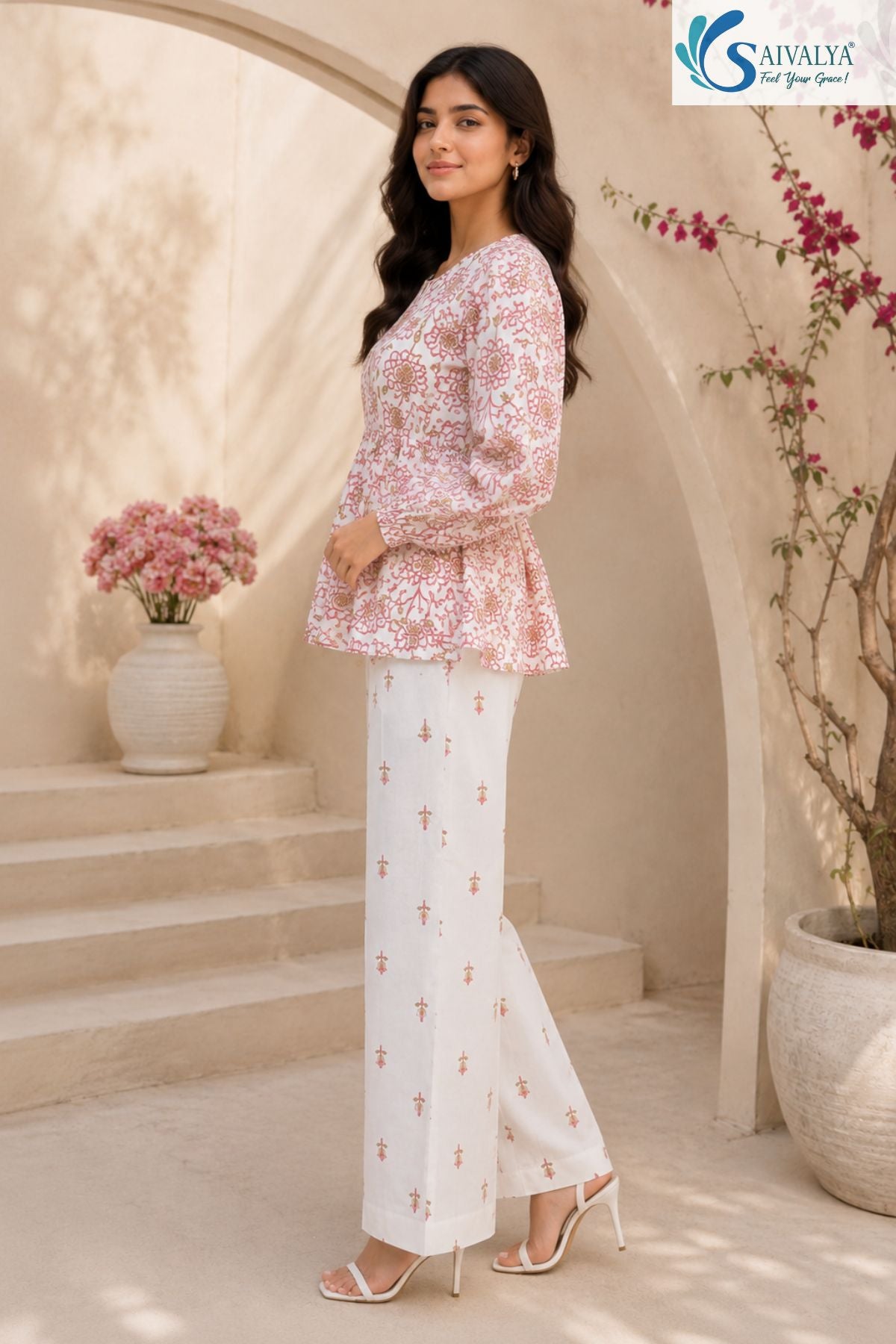 Side view of Bloom & Breezy Peplum Co-ord Set featuring floral printed peplum top with full sleeves and white straight palazzo pants for women ethnic casual wear by Saivalya.