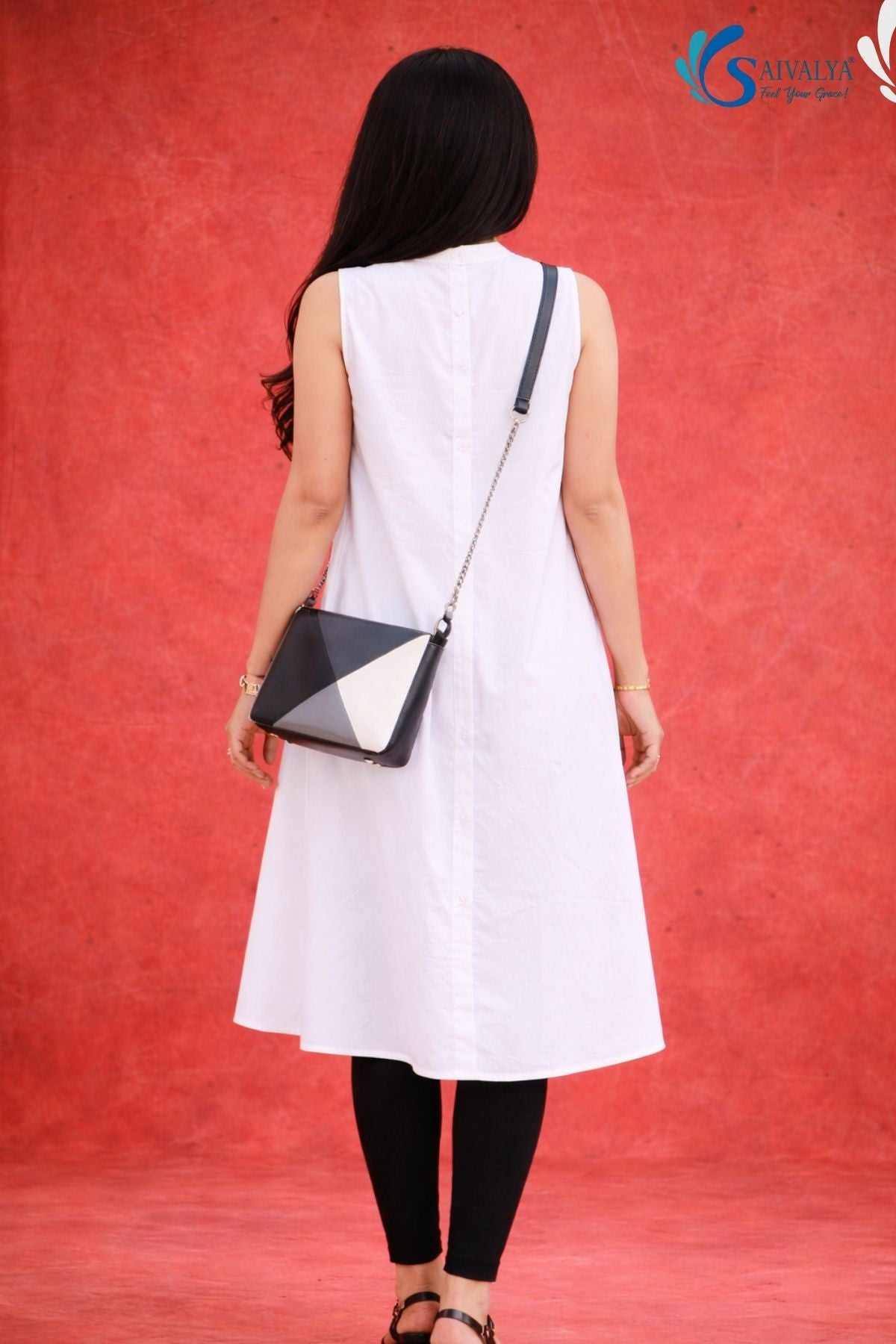 Back view of woman wearing Saivalya white pure cotton sleeveless high-low tunic with mandarin collar and button-down front