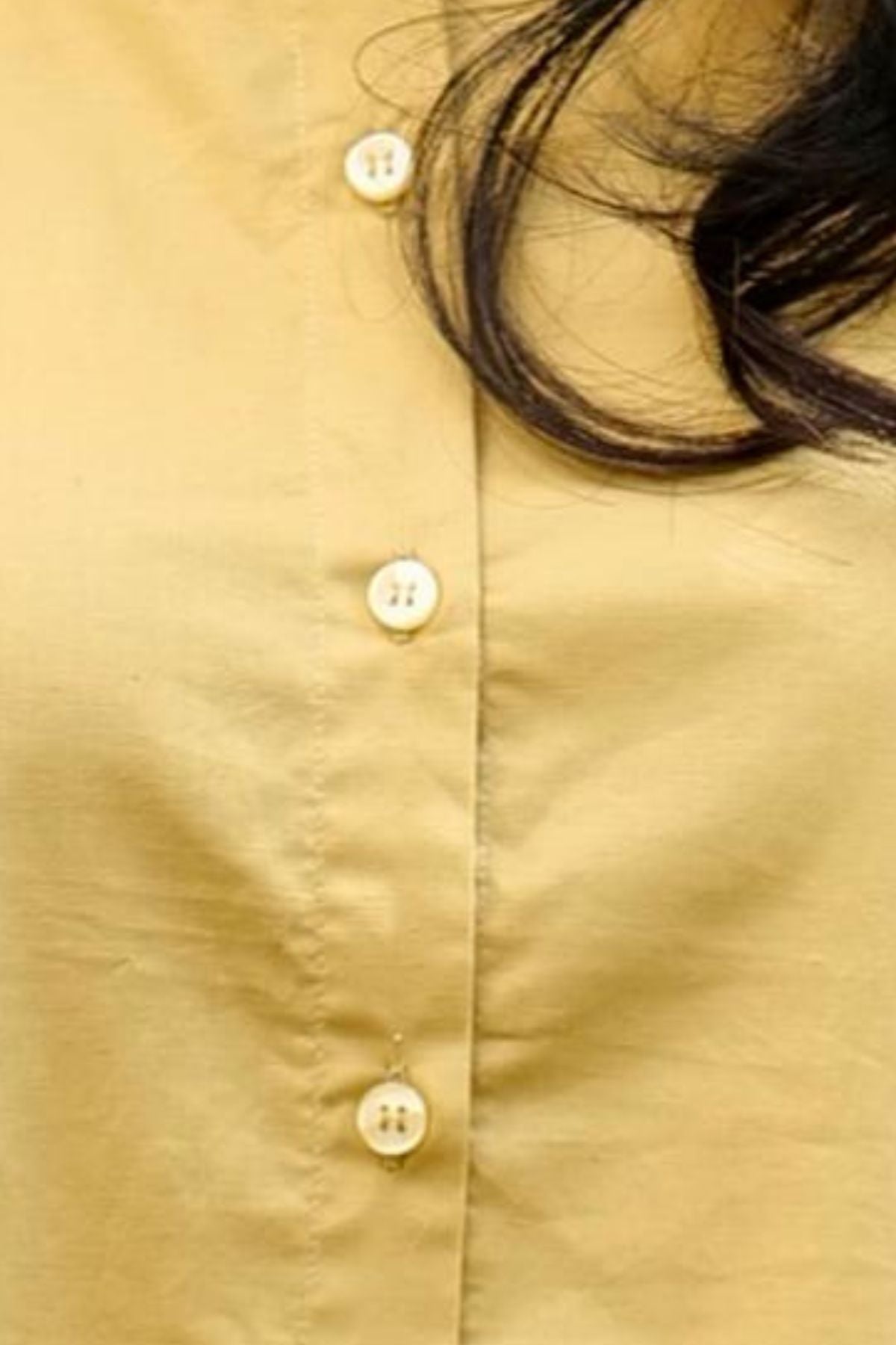 Close-up macro view highlighting the white round buttons on the front placket of the yellow fabric from the Ira Mustard High-Low Kurta.