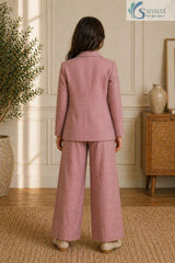 Back view of a young girl standing in a room, wearing the Rose Bloom 3-Piece Set featuring a mauve pink formal blazer and matching wide-leg trousers.