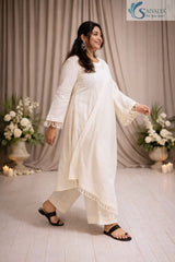 Side view of a woman posing in the Saivalya Ivory Loop Grace Suit highlighting the elegant drape of the dupatta and the clean silhouette of the ivory ensemble