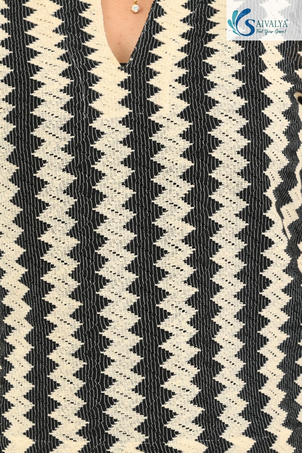 close view of a woman wearing Saivalya black and white vertical chevron print Ottoman jacquard knit top.