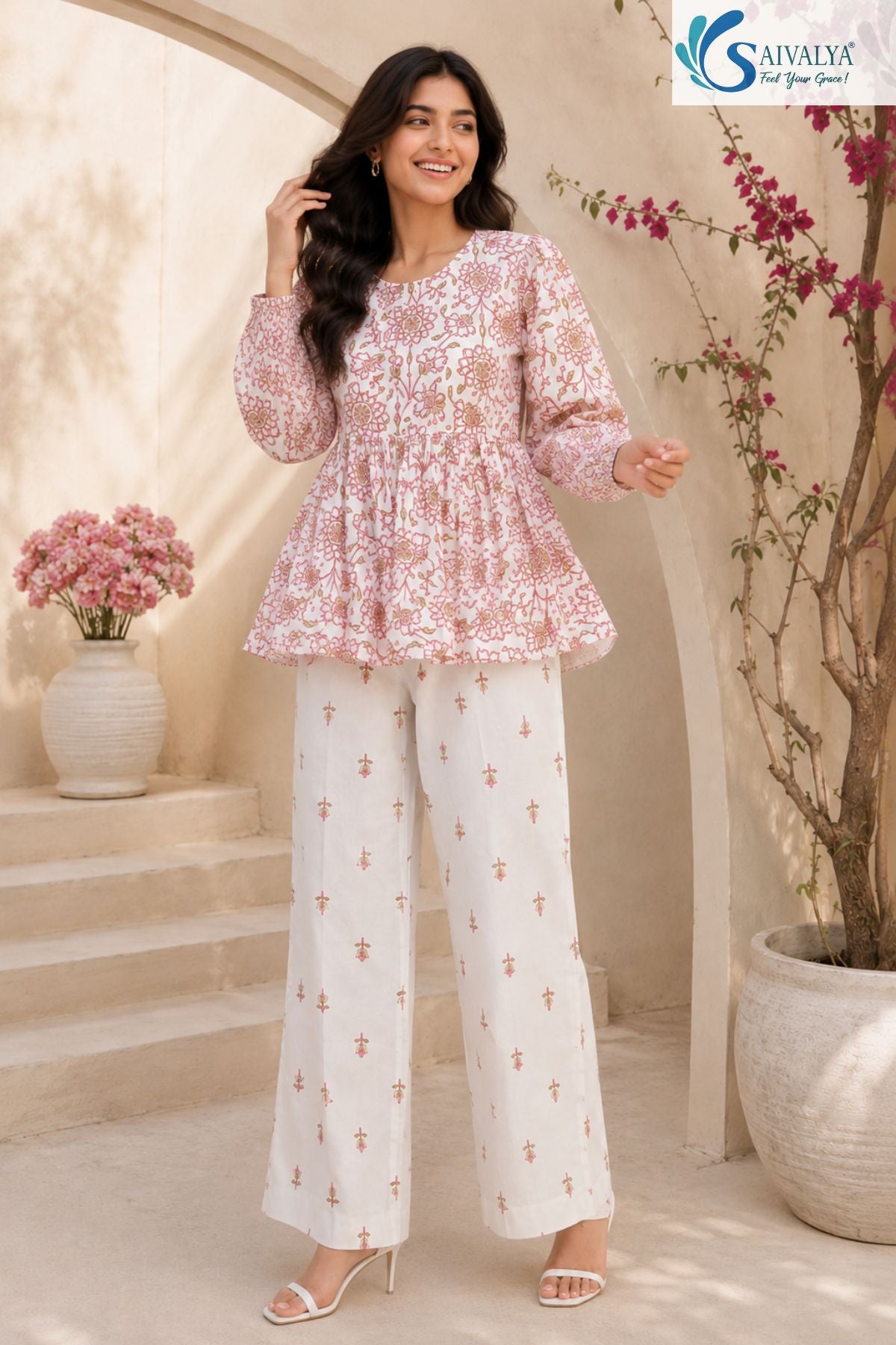 Bloom & Breezy Peplum Co-ord Set candid view featuring pink floral printed peplum top with full sleeves and white printed palazzo pants for women ethnic casual fashion by Saivalya.