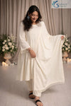 Front view of a woman wearing the Saivalya Ivory Loop Grace Suit featuring intricate loop button details and matching dupatta paired with straight fit trousers