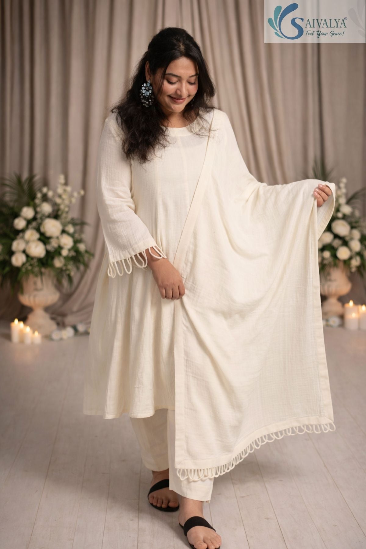 Front view of a woman wearing the Saivalya Ivory Loop Grace Suit featuring intricate loop button details and matching dupatta paired with straight fit trousers