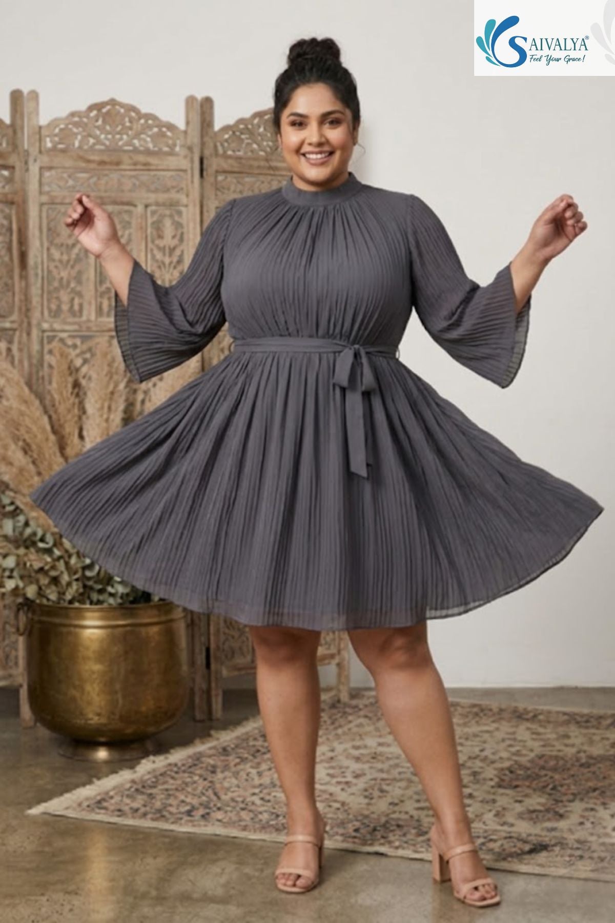 Plus size woman wearing a grey pleated high neck short dress with flare sleeves and a matching waist tie belt.