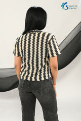 back view of a woman wearing Saivalya black and white vertical chevron print Ottoman jacquard knit top with a polo collar