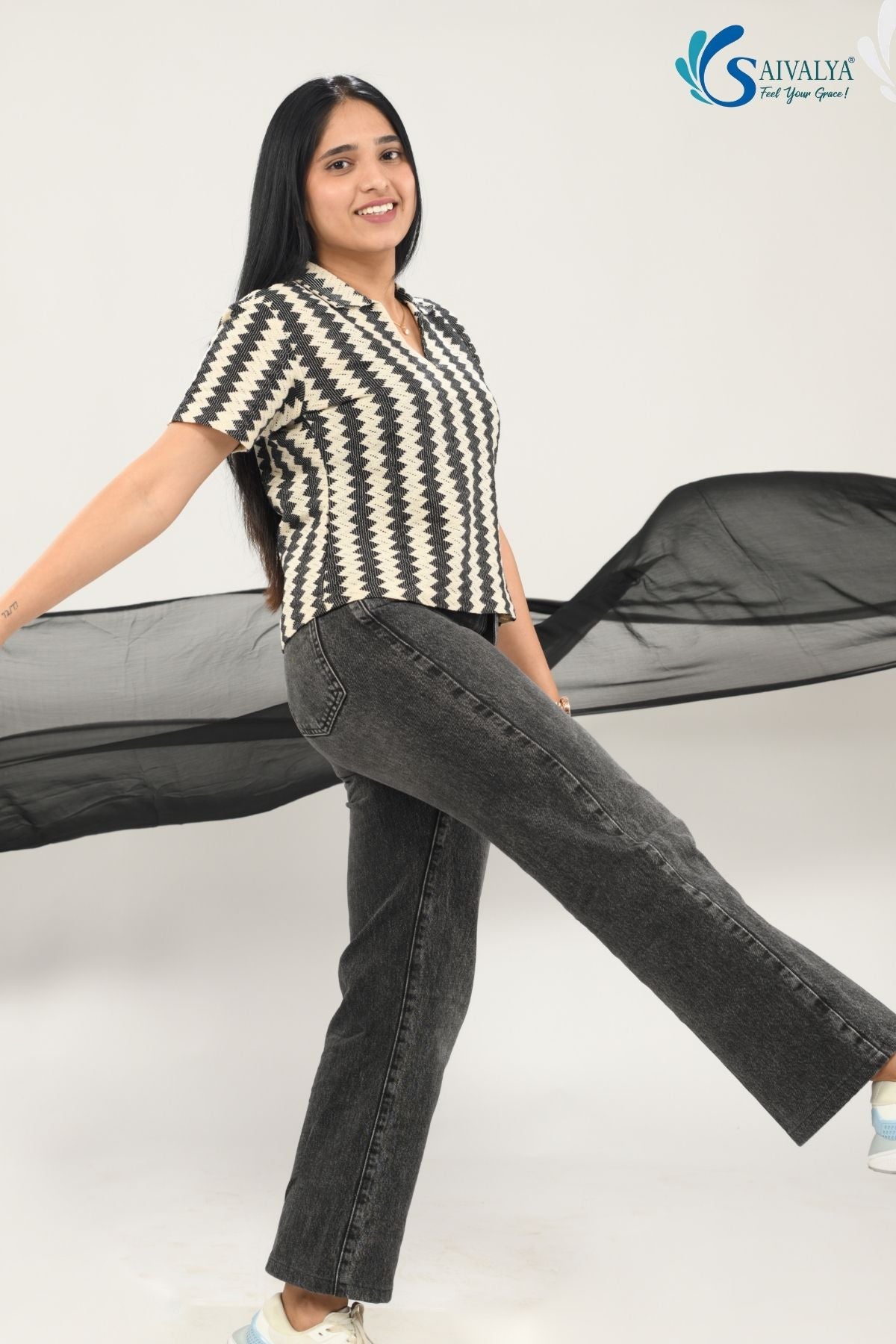 side view of a woman wearing Saivalya black and white vertical chevron print Ottoman jacquard knit top with a polo collar